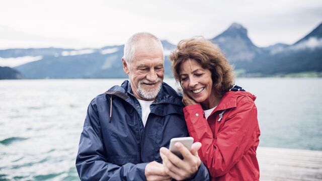 Eldre ektepar ser på mobil